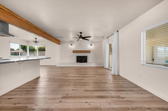 652 E Portals Ave, Fresno, CA 93710 - unfurnished living room featuring a ceiling fan, a fireplace with raised hearth, and wood finished floors