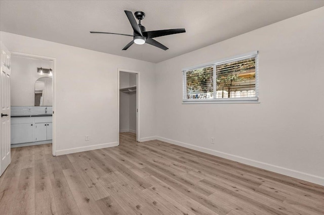 652 E Portals Ave, Fresno, CA 93710 - unfurnished bedroom featuring light wood-type flooring, a spacious closet, ensuite bath, and ceiling fan