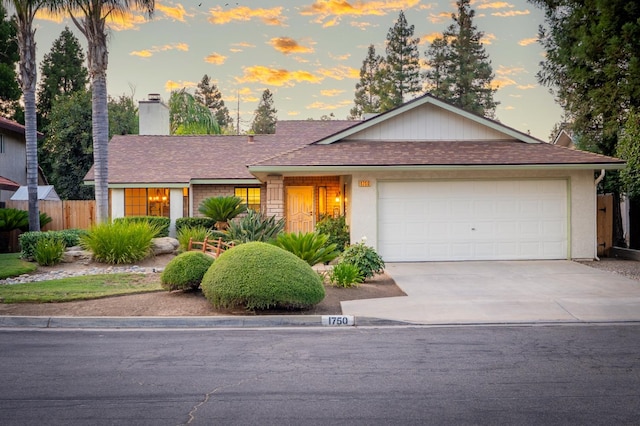 1750 E Deyoung, Fresno, CA 93720 - ranch-style home featuring a chimney, driveway, an attached garage, and roof with shingles