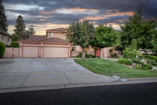 7664 N Kavanagh Ave, Fresno, CA 93711 - view of front facade featuring a tile roof, stucco siding, concrete driveway, an attached garage, and a lawn