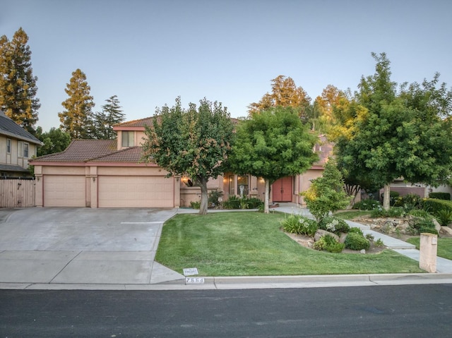 7664 N Kavanagh Ave, Fresno, CA 93711 - obstructed view of property with a garage, concrete driveway, a tile roof, a front yard, and stucco siding