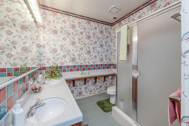 7664 N Kavanagh Ave, Fresno, CA 93711 - full bath with wallpapered walls, a stall shower, double vanity, tile patterned flooring, and wainscoting