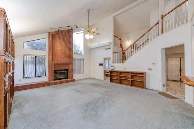 7664 N Kavanagh Ave, Fresno, CA 93711 - unfurnished living room featuring high vaulted ceiling, carpet, a ceiling fan, a fireplace, and stairs