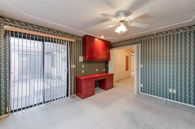 7664 N Kavanagh Ave, Fresno, CA 93711 - kitchen featuring wallpapered walls, red cabinets, a ceiling fan, light carpet, and dark countertops