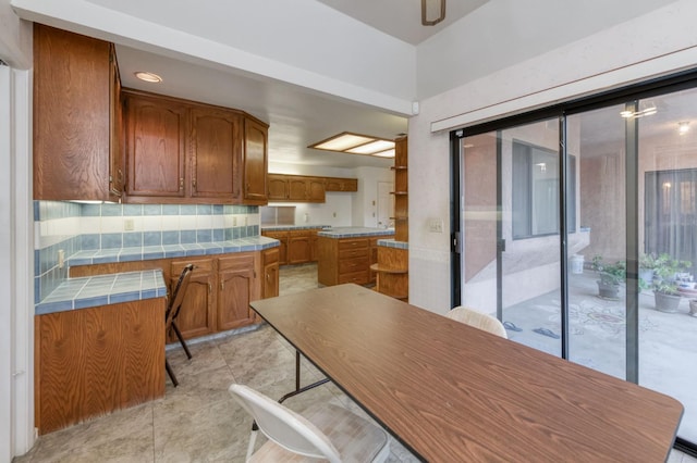 7664 N Kavanagh Ave, Fresno, CA 93711 - kitchen featuring tile counters, brown cabinets, backsplash, and light tile patterned floors