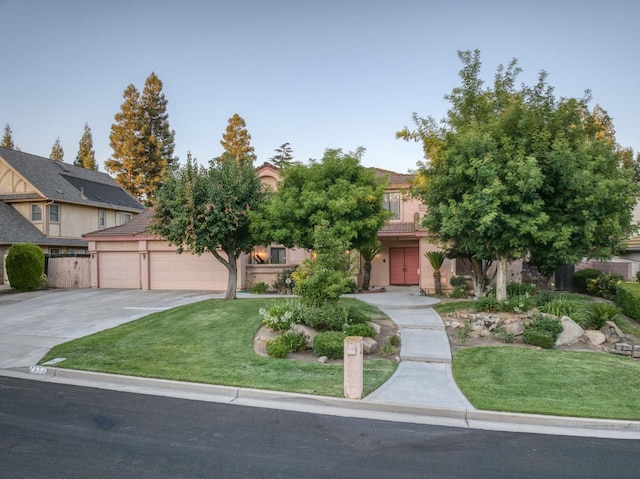 7664 N Kavanagh Ave, Fresno, CA 93711 - obstructed view of property with concrete driveway, a tile roof, a garage, and stucco siding