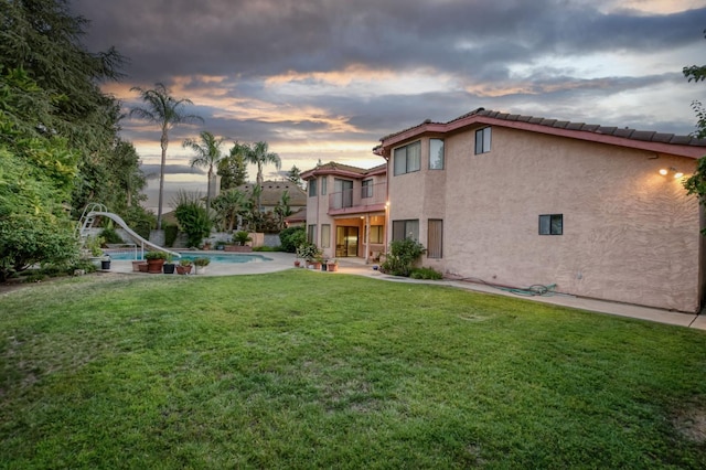 7664 N Kavanagh Ave, Fresno, CA 93711 - back of house with a balcony, stucco siding, a yard, an outdoor pool, and a patio
