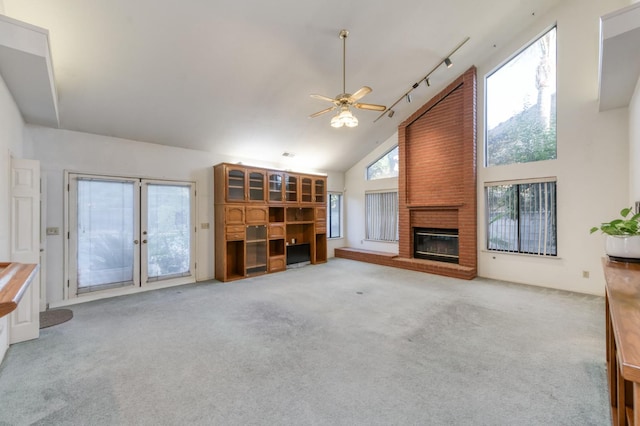 7664 N Kavanagh Ave, Fresno, CA 93711 - unfurnished living room with a brick fireplace, light colored carpet, a ceiling fan, high vaulted ceiling, and french doors