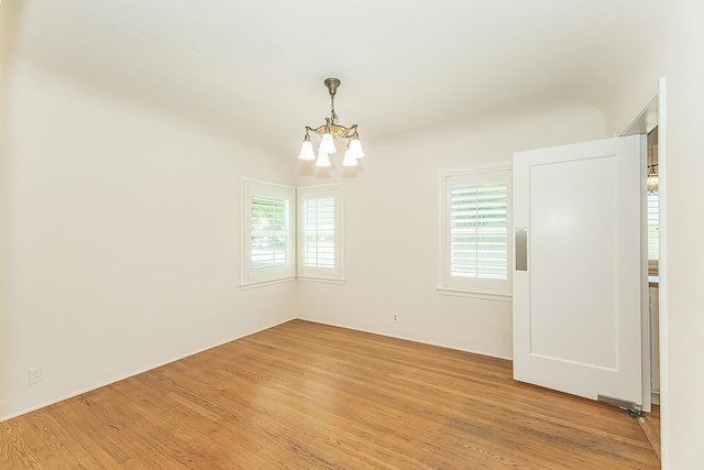 4845 Arcade Ave, Fresno, CA 93704 - empty room featuring a chandelier, healthy amount of natural light, and light wood-style flooring
