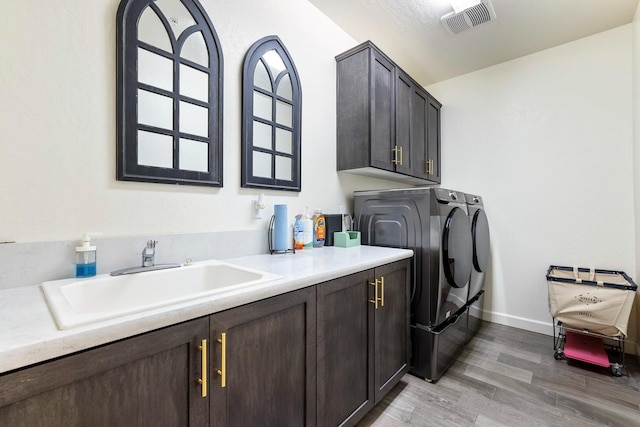 2421 N Cabrenet Pl, Hanford, CA 93230 - washroom with washing machine and clothes dryer, cabinet space, and light wood-style floors