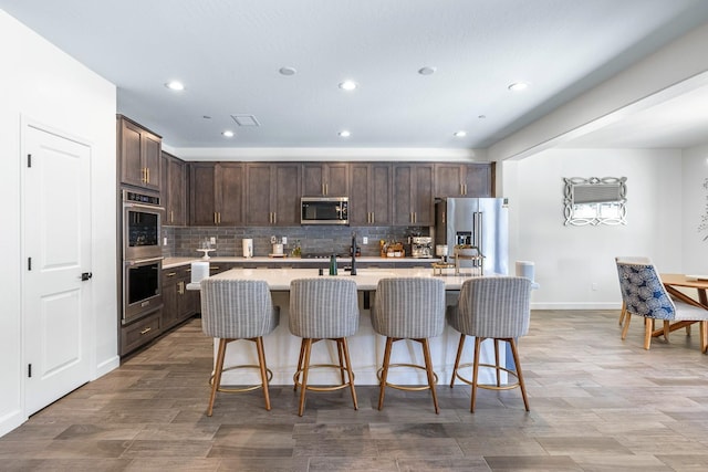 2421 N Cabrenet Pl, Hanford, CA 93230 - kitchen featuring appliances with stainless steel finishes, dark brown cabinets, light countertops, recessed lighting, and backsplash