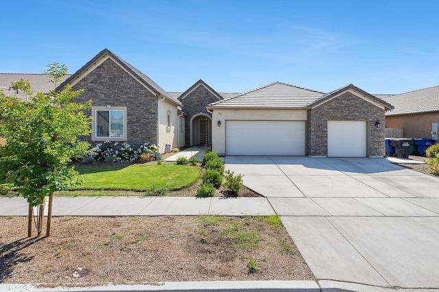 2421 N Cabrenet Pl, Hanford, CA 93230 - view of front of home with a garage, driveway, stucco siding, a tile roof, and a front lawn