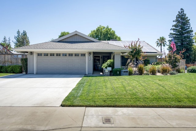 365 Stanford Ave, Clovis, CA 93611 - ranch-style home featuring roof mounted solar panels, a front yard, driveway, and a garage