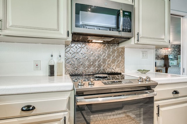5180 N Wishon Ave Unit 103, Fresno, CA 93704 - kitchen with stainless steel appliances, decorative backsplash, and tile countertops