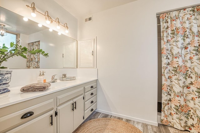 5180 N Wishon Ave Unit 103, Fresno, CA 93704 - full bathroom with vanity, wood finished floors, and a shower with curtain