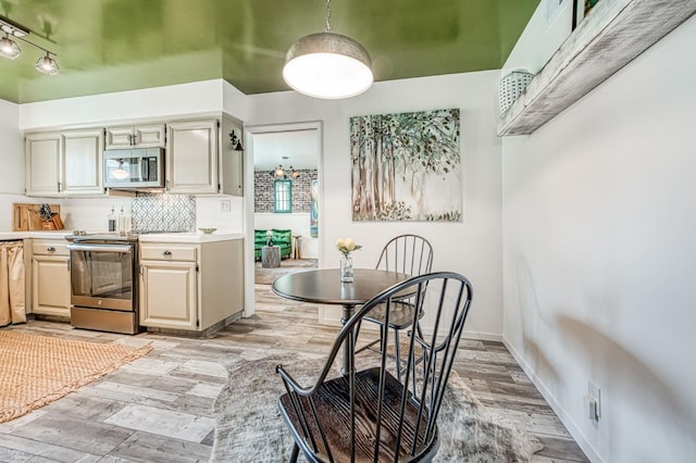 5180 N Wishon Ave Unit 103, Fresno, CA 93704 - kitchen with appliances with stainless steel finishes, light wood-type flooring, light countertops, and decorative backsplash