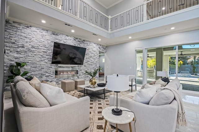 7160 W Dovewood Ln, Fresno, CA 93723 - living area with a high ceiling, a glass covered fireplace, recessed lighting, and crown molding