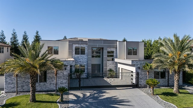 7160 W Dovewood Ln, Fresno, CA 93723 - contemporary house featuring stone siding, a gate, stucco siding, and driveway