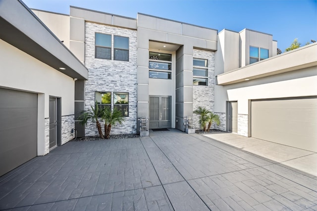 7160 W Dovewood Ln, Fresno, CA 93723 - contemporary house featuring stone siding, french doors, a garage, and stucco siding