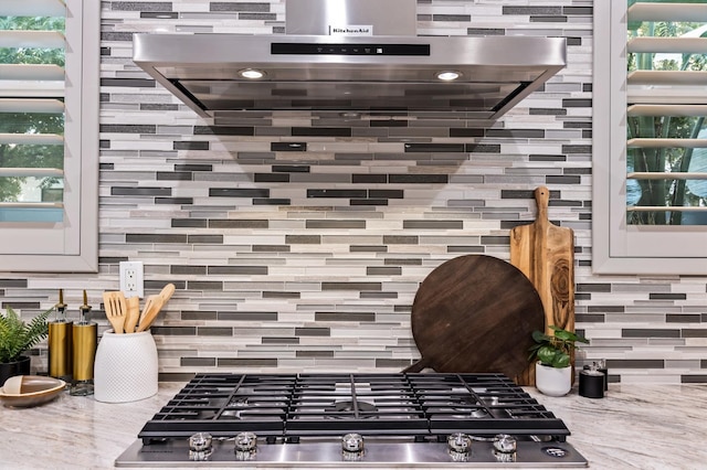 7160 W Dovewood Ln, Fresno, CA 93723 - kitchen view of stainless steel gas cooktop, extractor fan, tasteful backsplash, and light stone counters
