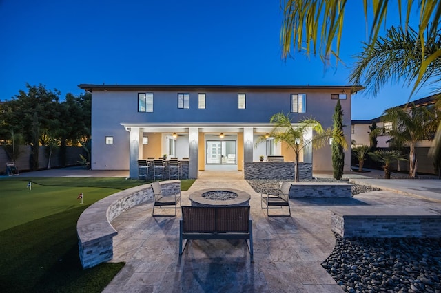 7160 W Dovewood Ln, Fresno, CA 93723 - rear view of property with an outdoor fire pit, stucco siding, a patio area, a putting area, and french doors