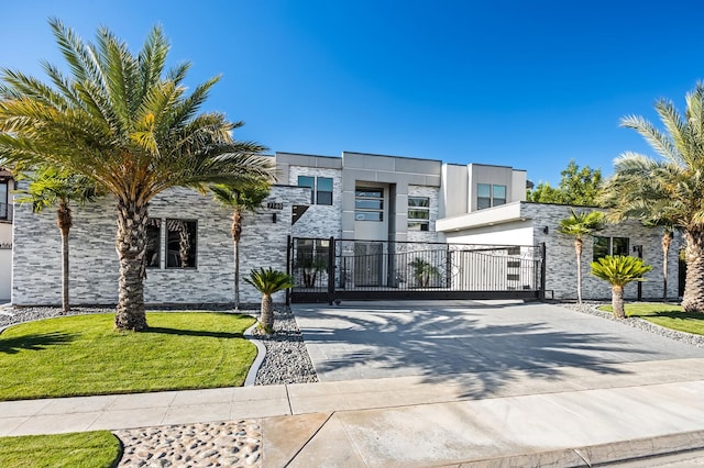 7160 W Dovewood Ln, Fresno, CA 93723 - modern home featuring a gate, stone siding, driveway, an attached garage, and stucco siding