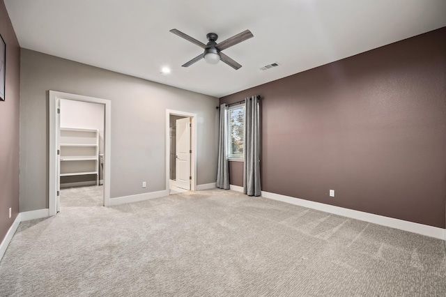 7160 W Dovewood Ln, Fresno, CA 93723 - unfurnished bedroom with a walk in closet, light carpet, a ceiling fan, connected bathroom, and recessed lighting