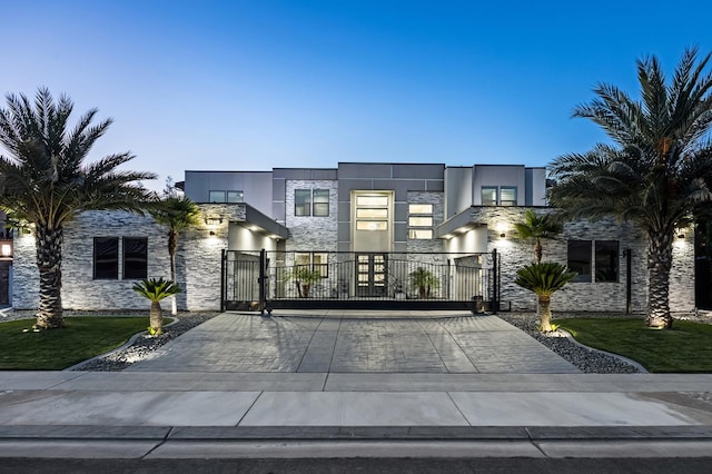 7160 W Dovewood Ln, Fresno, CA 93723 - contemporary house with stone siding, a gate, and stucco siding