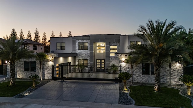 7160 W Dovewood Ln, Fresno, CA 93723 - modern home with stone siding, a gate, stucco siding, and driveway