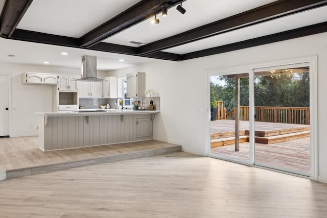 9098 San Gabriel Rd, Atascadero, CA 93422 - kitchen with island range hood, light wood-type flooring, a peninsula, beamed ceiling, and plenty of natural light