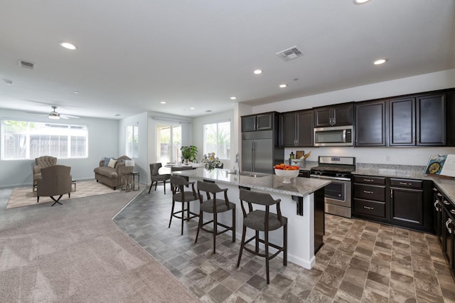 7173 N Shiraz, Fresno, CA 93722 - kitchen with appliances with stainless steel finishes, plenty of natural light, open floor plan, a kitchen island with sink, and recessed lighting