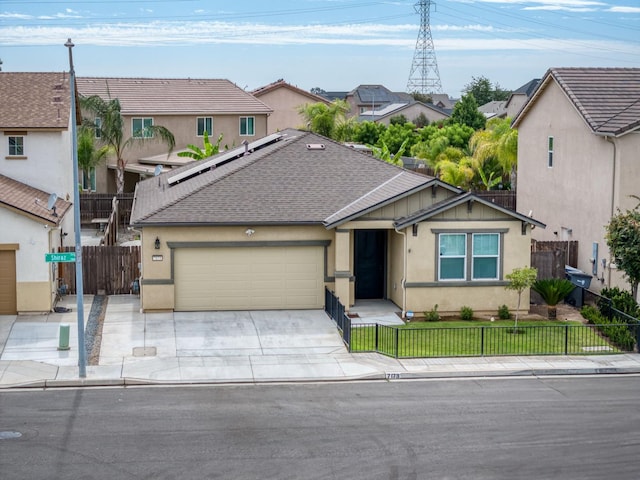 7173 N Shiraz, Fresno, CA 93722 - view of front of home featuring a garage, concrete driveway, stucco siding, roof mounted solar panels, and a residential view