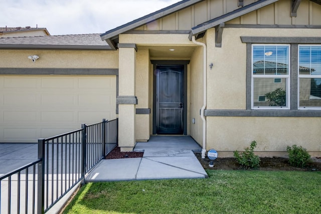 7173 N Shiraz, Fresno, CA 93722 - doorway to property with board and batten siding, a garage, and stucco siding