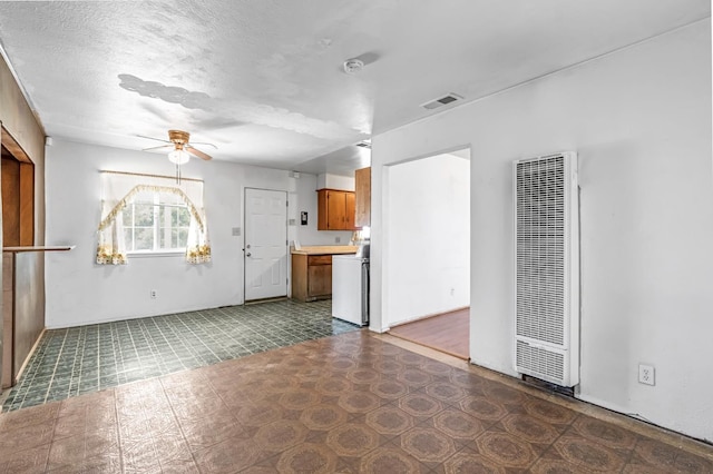 8573 E Ostler St, Selma, CA 93662 - unfurnished living room featuring a heating unit, a ceiling fan, tile patterned floors, and a textured ceiling