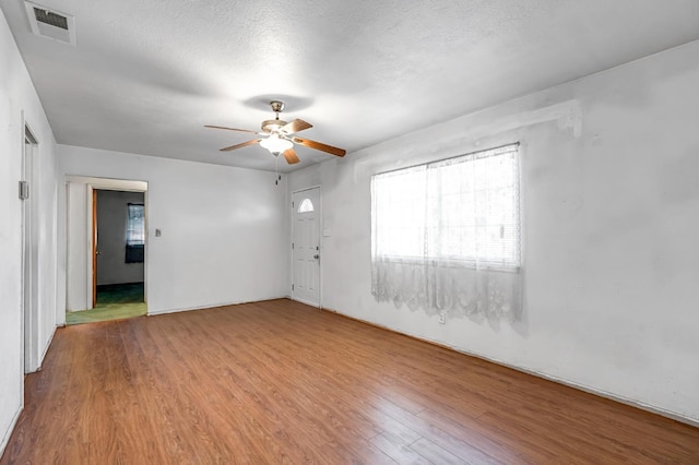 8573 E Ostler St, Selma, CA 93662 - unfurnished room with wood finished floors, healthy amount of natural light, ceiling fan, and a textured ceiling