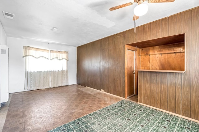 8573 E Ostler St, Selma, CA 93662 - unfurnished room with wooden walls, tile patterned floors, ceiling fan, a smoke detector, and a heating unit