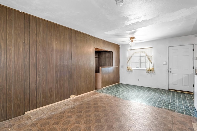 8573 E Ostler St, Selma, CA 93662 - entryway with a ceiling fan, wood walls, tile patterned floors, and a textured ceiling