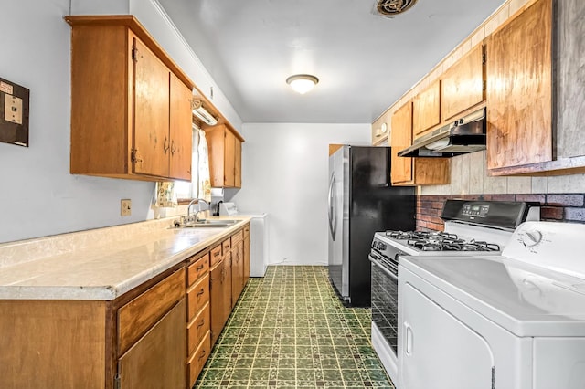 8573 E Ostler St, Selma, CA 93662 - kitchen featuring washer / clothes dryer, under cabinet range hood, dark flooring, and light countertops