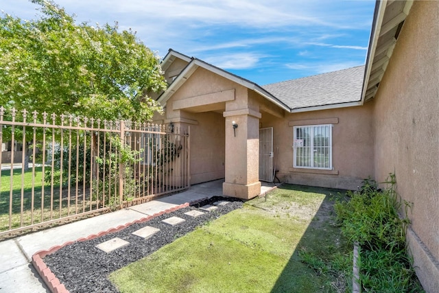 3615 W Michigan Ave, Fresno, CA 93722 - property entrance with stucco siding and a shingled roof