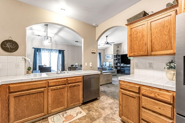3615 W Michigan Ave, Fresno, CA 93722 - kitchen featuring dishwasher, open floor plan, arched walkways, a ceiling fan, and decorative backsplash
