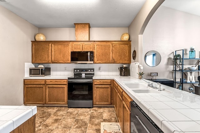 3615 W Michigan Ave, Fresno, CA 93722 - kitchen featuring stainless steel microwave, black electric range oven, and tile countertops