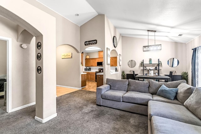 3615 W Michigan Ave, Fresno, CA 93722 - living room with arched walkways, vaulted ceiling, and light colored carpet