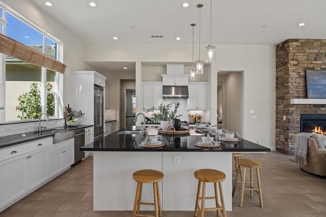 998 Highland Rd W, Madera, CA 93636 - kitchen featuring stainless steel appliances, dark countertops, backsplash, under cabinet range hood, and white cabinetry