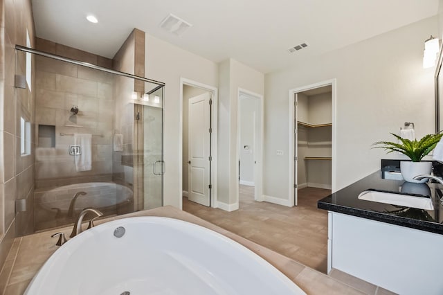 998 Highland Rd W, Madera, CA 93636 - bathroom with double vanity, a shower stall, a tub, a walk in closet, and recessed lighting