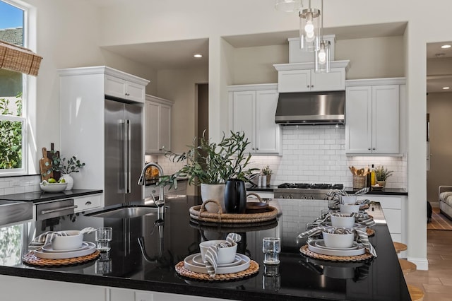 998 Highland Rd W, Madera, CA 93636 - kitchen featuring appliances with stainless steel finishes, under cabinet range hood, dark countertops, tasteful backsplash, and recessed lighting
