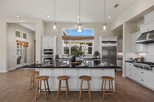998 Highland Rd W, Madera, CA 93636 - kitchen featuring stainless steel appliances, range hood, decorative backsplash, dark countertops, and white cabinetry