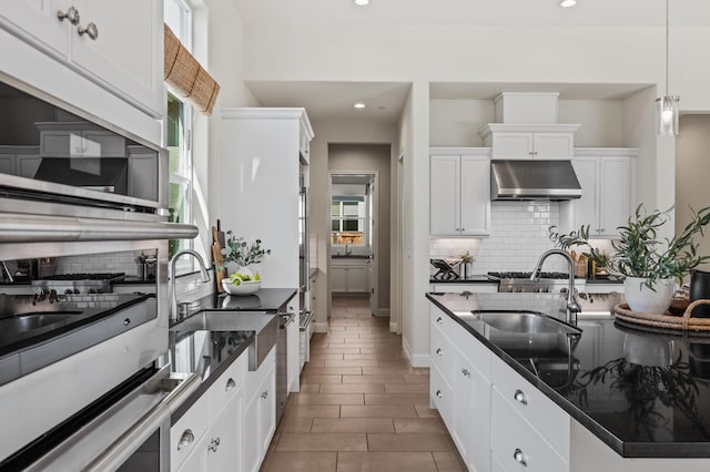 998 Highland Rd W, Madera, CA 93636 - kitchen featuring under cabinet range hood, tasteful backsplash, white microwave, white cabinetry, and recessed lighting