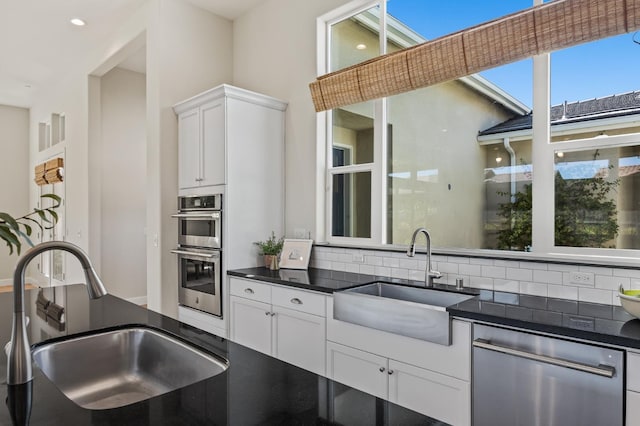 998 Highland Rd W, Madera, CA 93636 - kitchen featuring appliances with stainless steel finishes, dark countertops, decorative backsplash, white cabinets, and recessed lighting