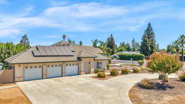 431 S Fowler Ave, Fresno, CA 93727 - view of front of house featuring concrete driveway, solar panels, an attached garage, stucco siding, and a tiled roof