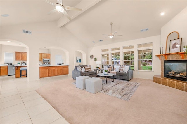 431 S Fowler Ave, Fresno, CA 93727 - living room with a ceiling fan, high vaulted ceiling, arched walkways, a tiled fireplace, and beamed ceiling